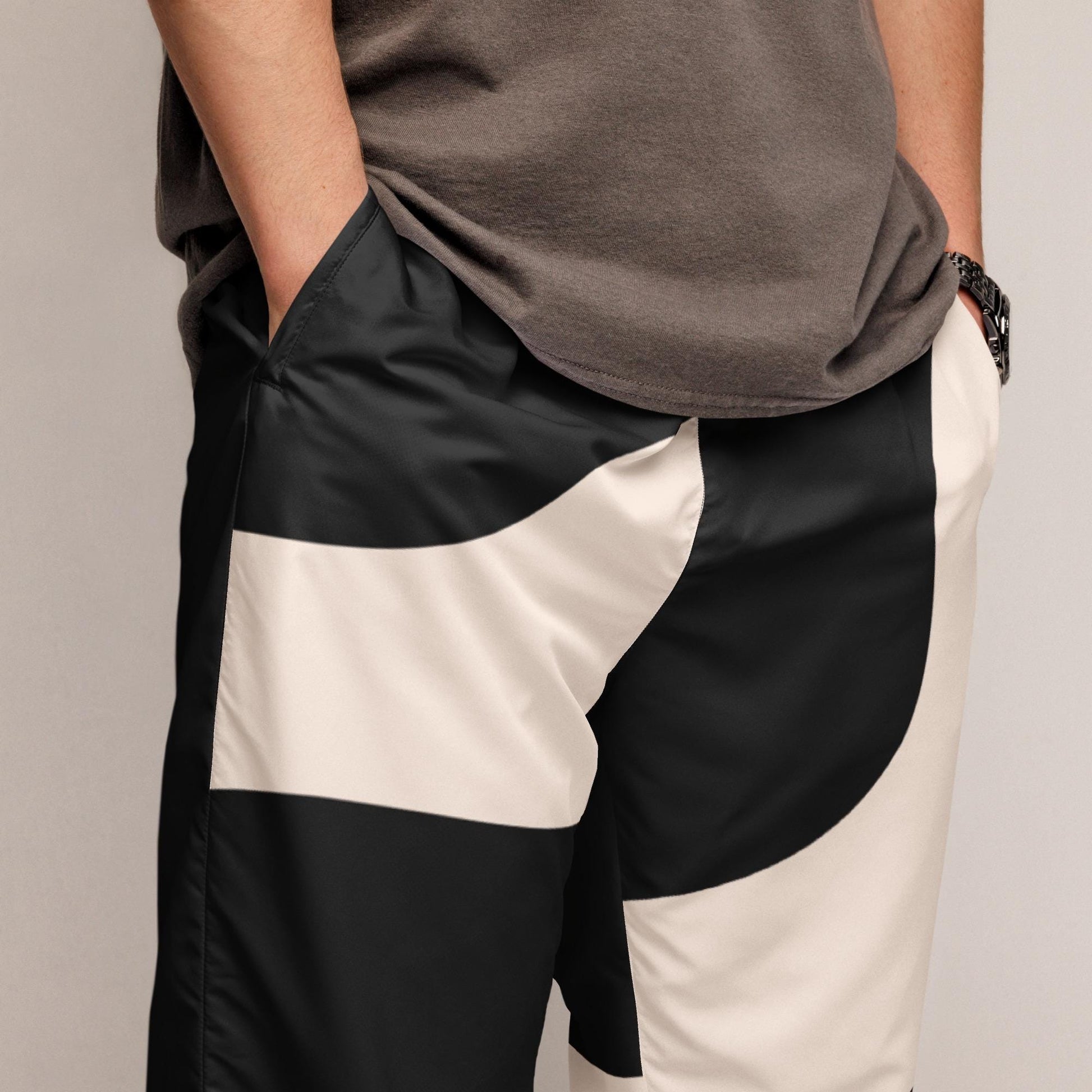 Détail **motif imprimé** et texture du tissu - pantalon homme - beige et noir - imprimé graphique minimaliste